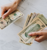 hands holding cash to pay employee
